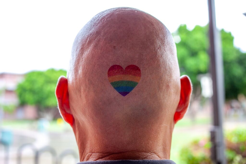 person with heart rainbow tattoo on scalp